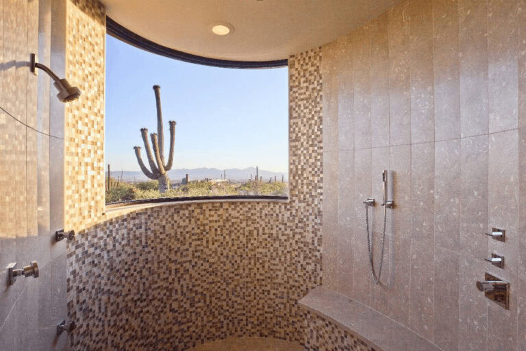 Walk-in shower tile ideas with natural-toned mosaic tiles on curved wall and large picture window
