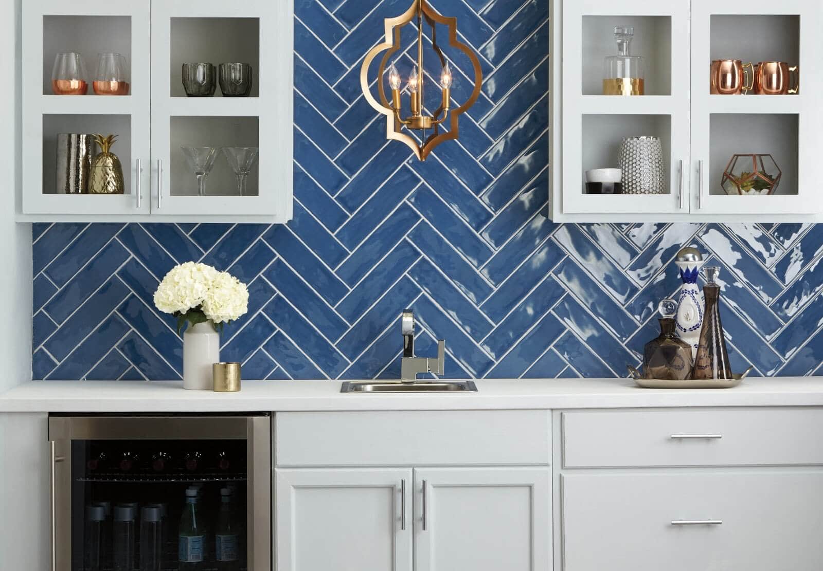 Kitchen backsplash with blue ceramic tile in a herringbone pattern