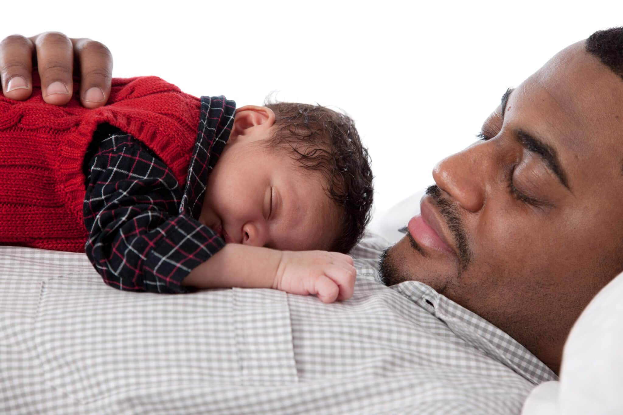 A newborn baby boy sleeps on his father's chest