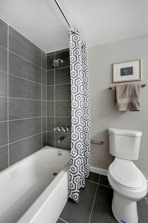Shower with gray stone-look tile in a horizontal grid