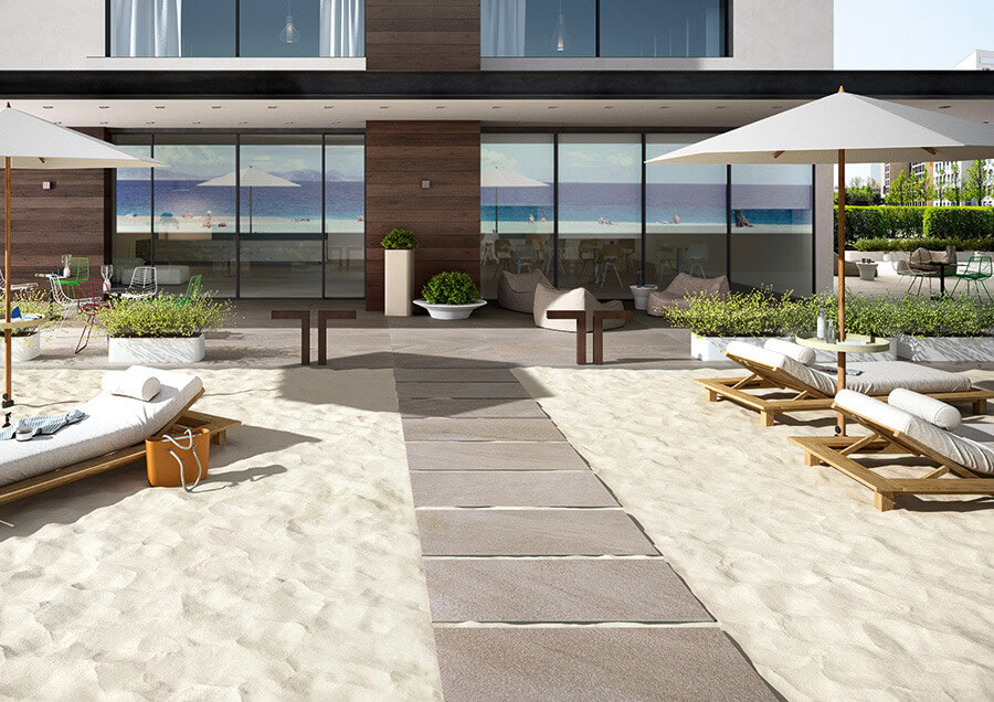 Beach home patio with pavers between sand
