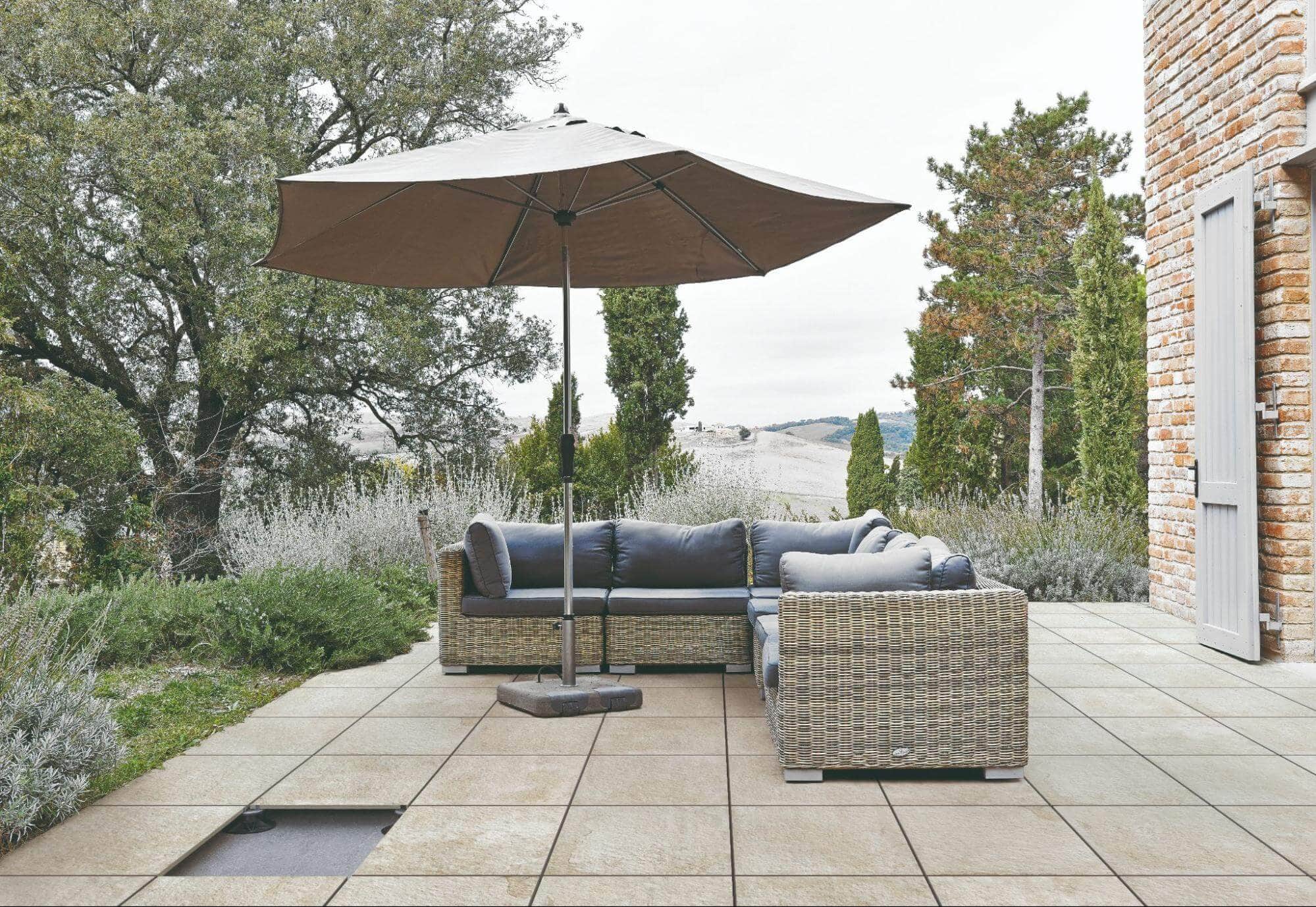 Outdoor seating space with porcelain pavers installed on raised pedestals or floating installation