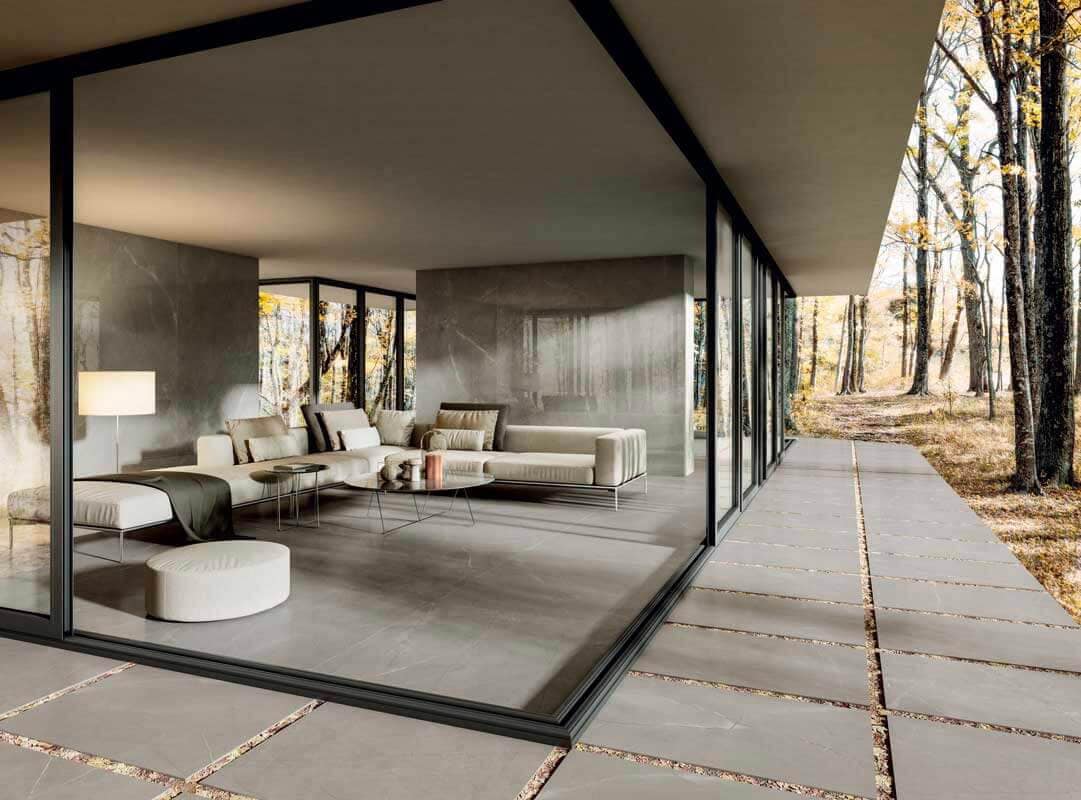 Transition from living room to outside with glass walls and gray porcelain pavels 