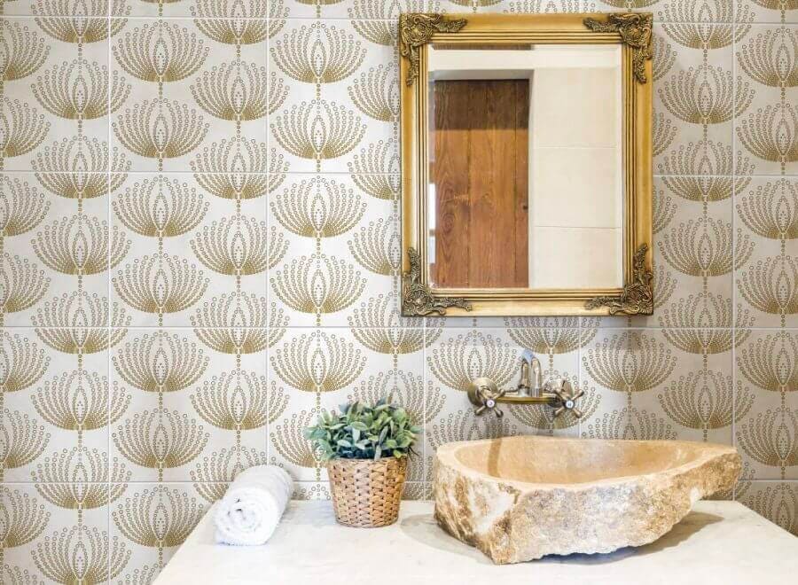 Bathroom sink with backsplash tile and a gold pattern
