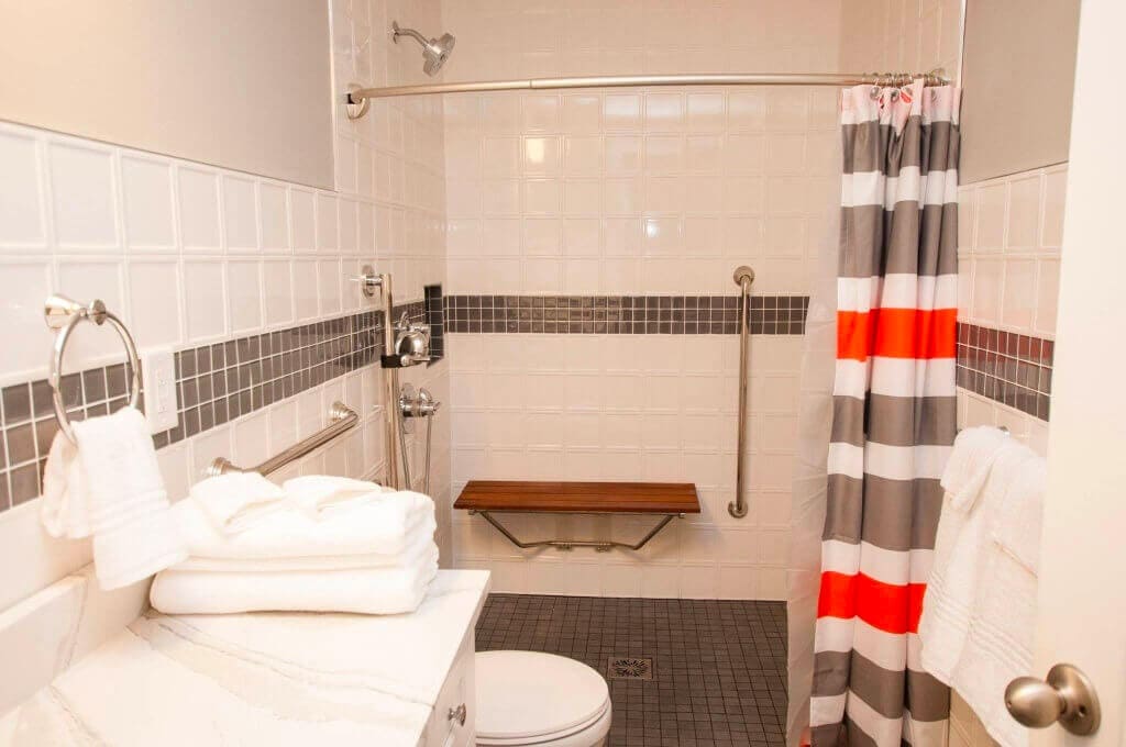 White bathroom with white backsplash tile and a gray tile border
