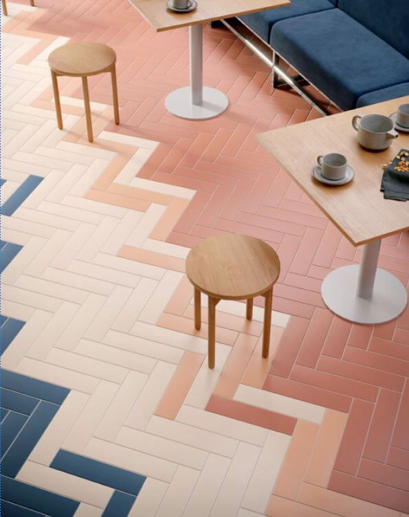 Kitchen floor with herringbone design and different pale blush pink floor tiles 
