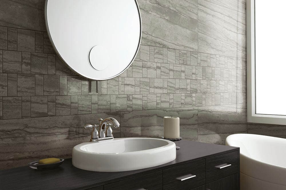 Bathroom sink with gray stone-look tile in small and large rectangles

