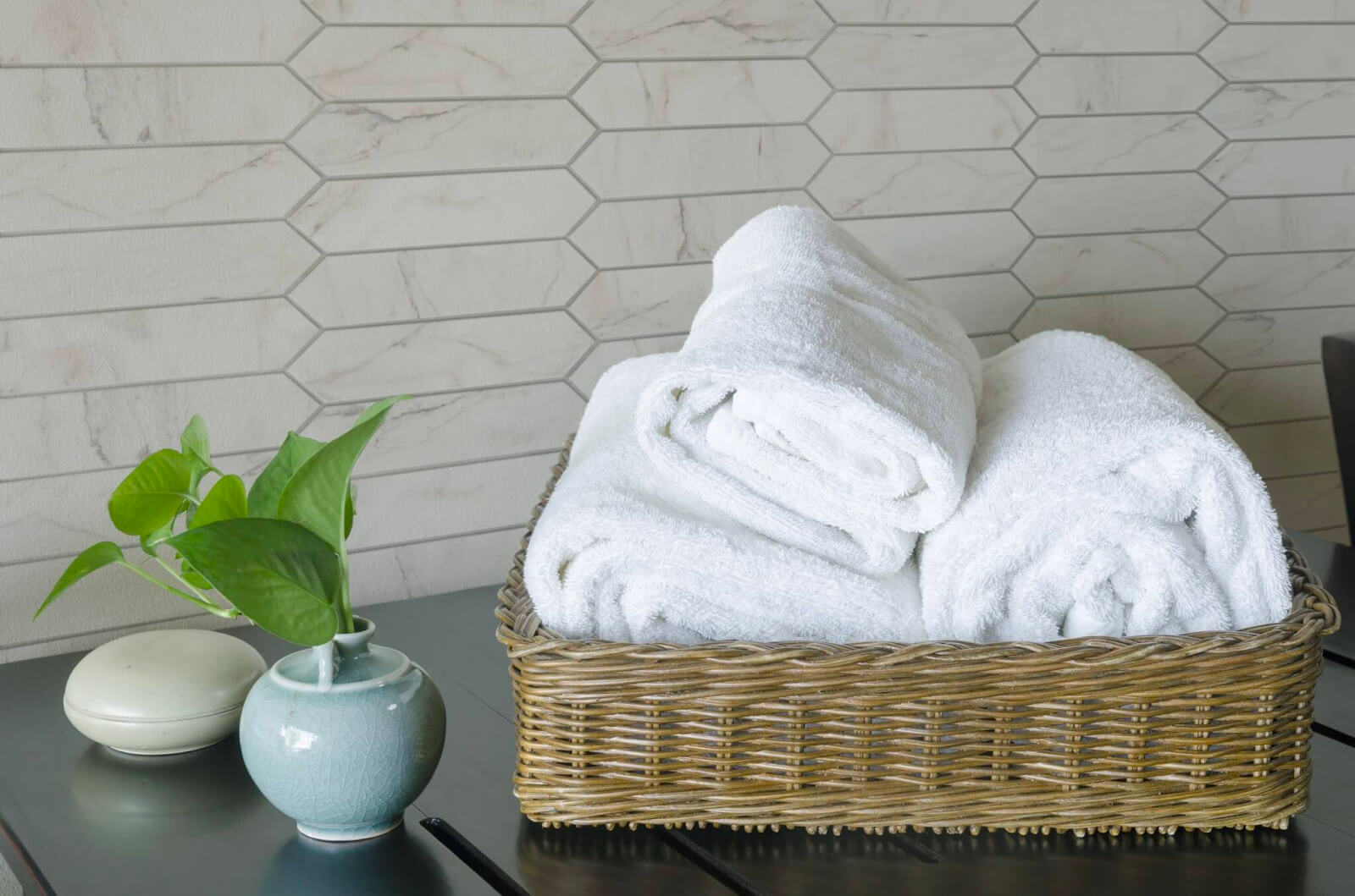 Bathroom towels with white marble-look tile in a horizontal picket fence layout

