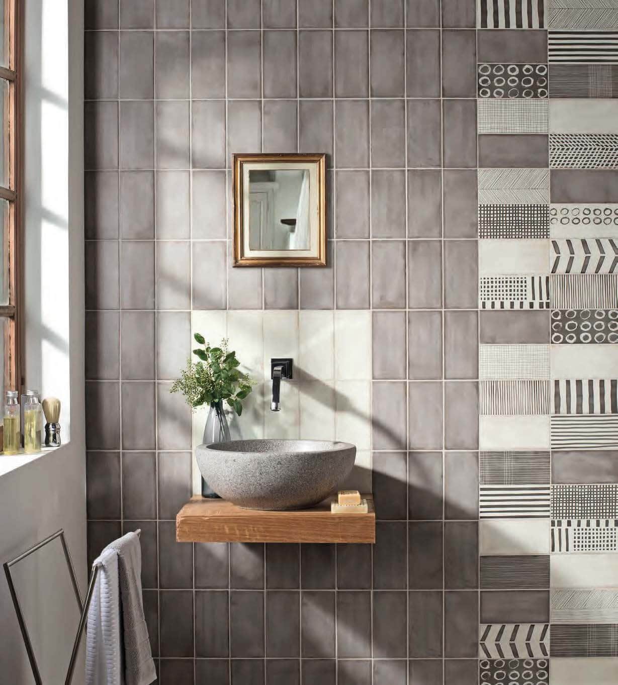 Bathroom with variegated and patterned gray tile wall