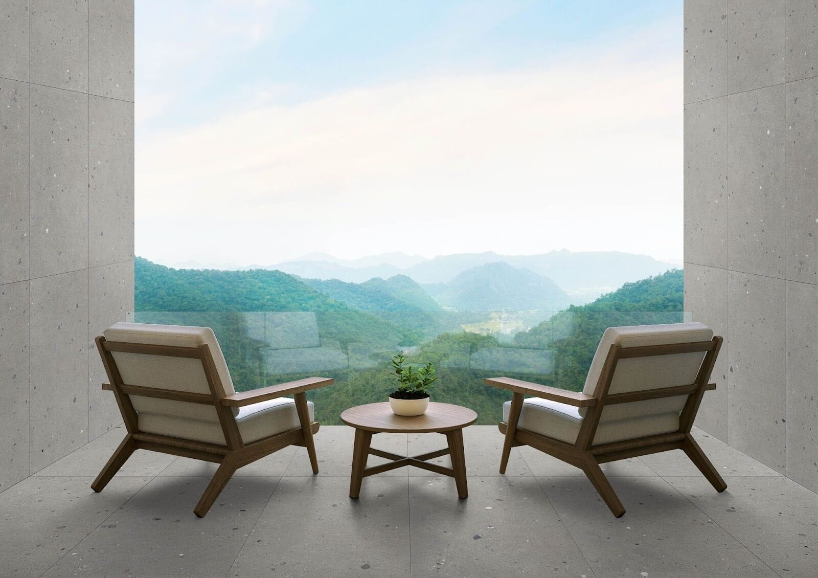 Two wooden mid-century modern chairs with a side table inbetween, facing a floor-to-ceiling window overlooking a green, scenic landscape.