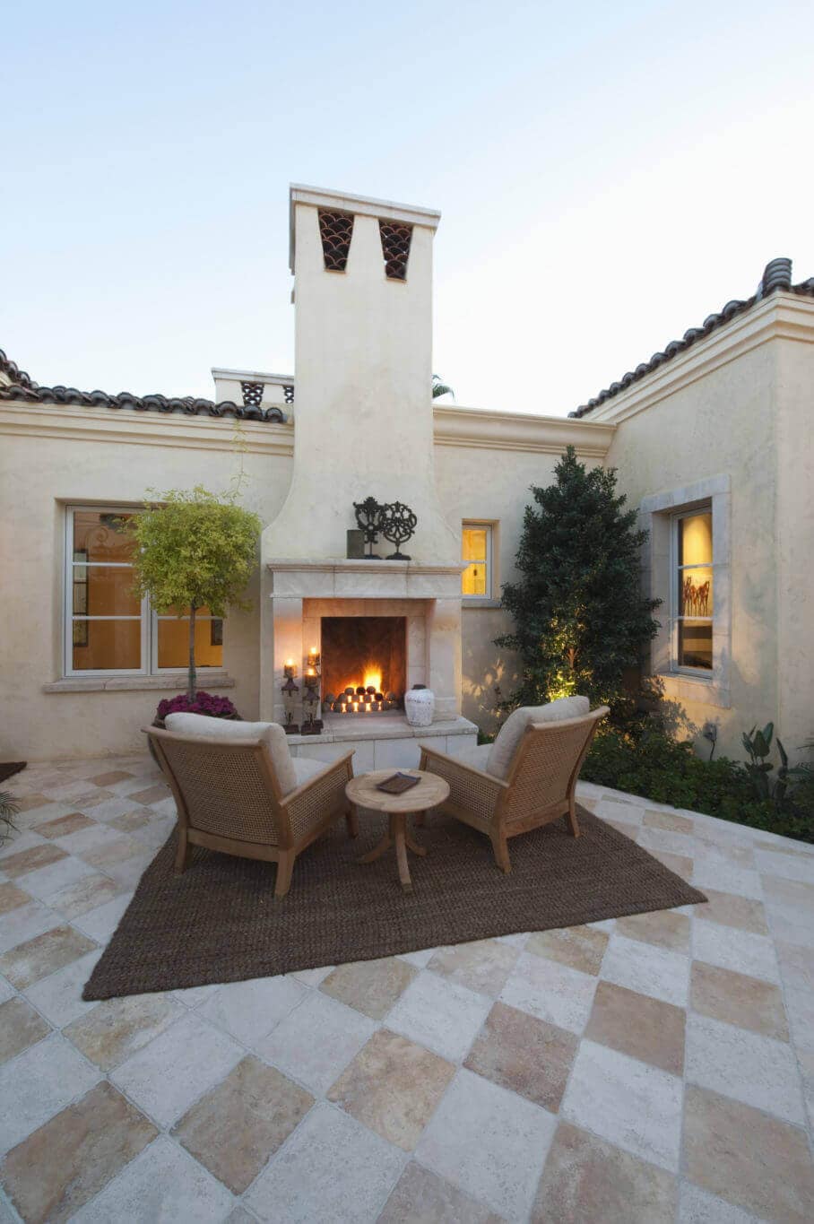 Checkerboard quarry tile flooring for outdoor space with a fireplace
