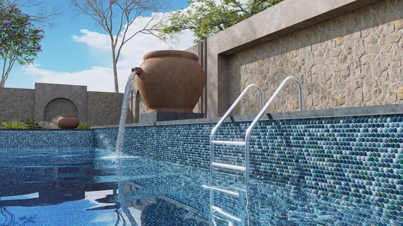 Lateral look of exterior pool with penny round mosaics in rich blues and greens
