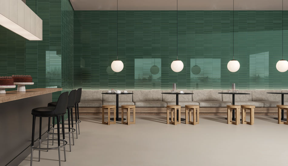 Cafe interior with colorful rich green tile walls and hanging globe lights