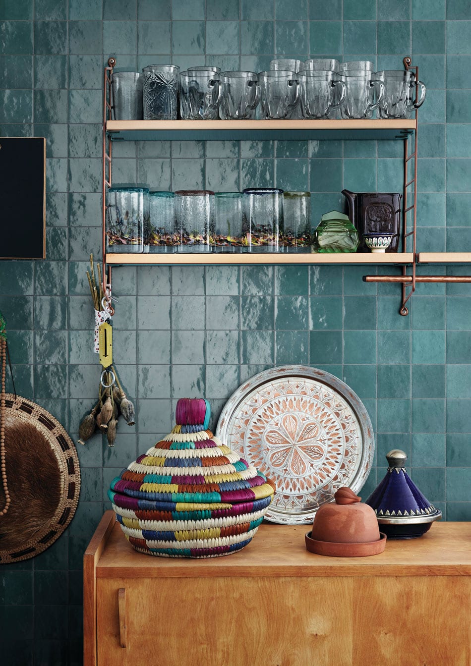 Kitchen backsplash of blue-tinged zellige tile shimmers across this kitchen wall and glassware