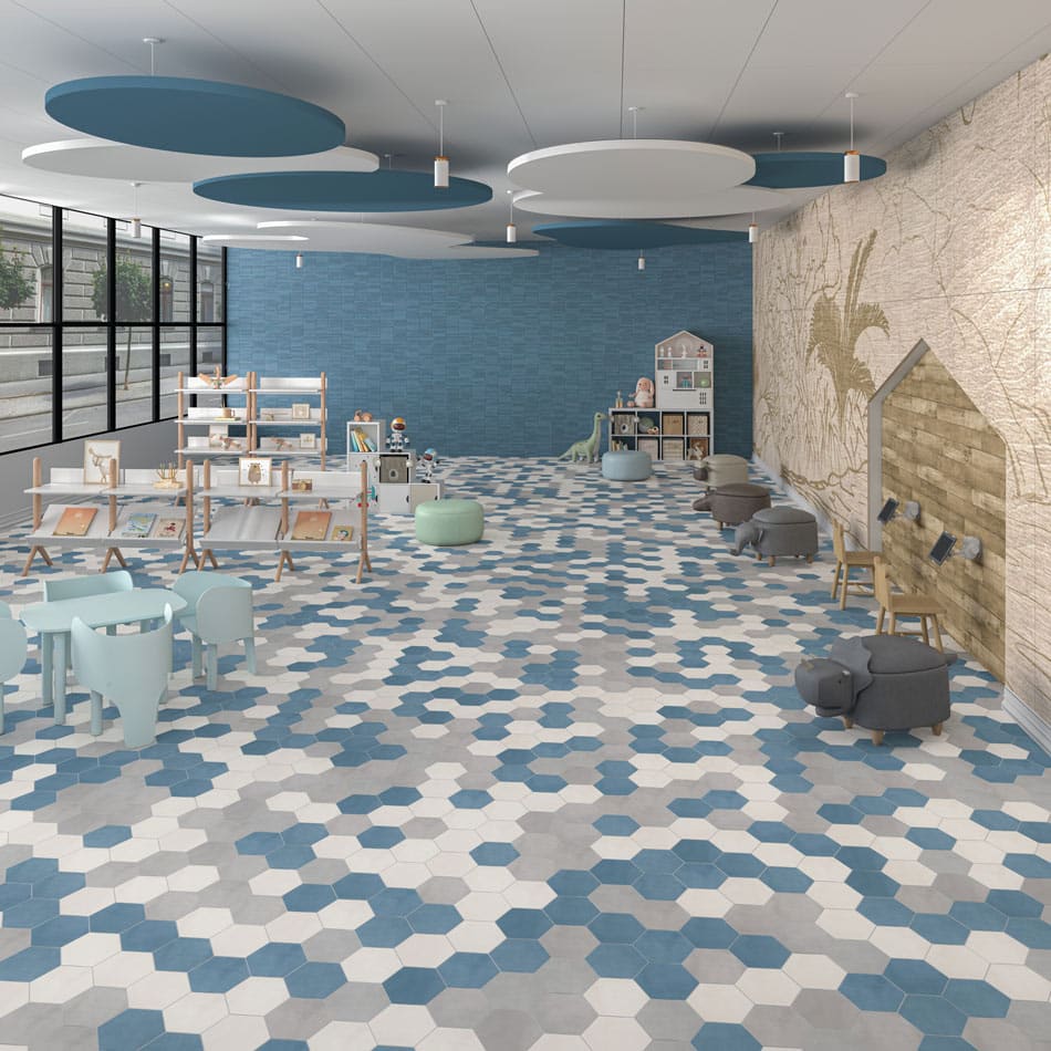 Daycare playroom with hex mosaic floor tile in denim-blue, gray, and white, paired with blue grooved accent wall