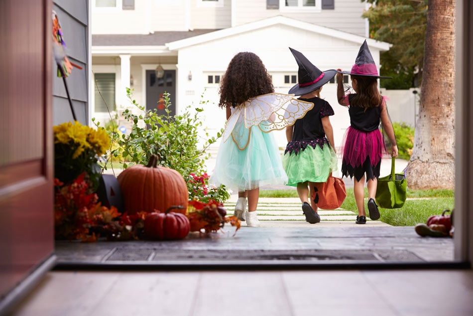 Children in Halloween costumes walking outside with eggshell-white interior tile and black paver tile porch
