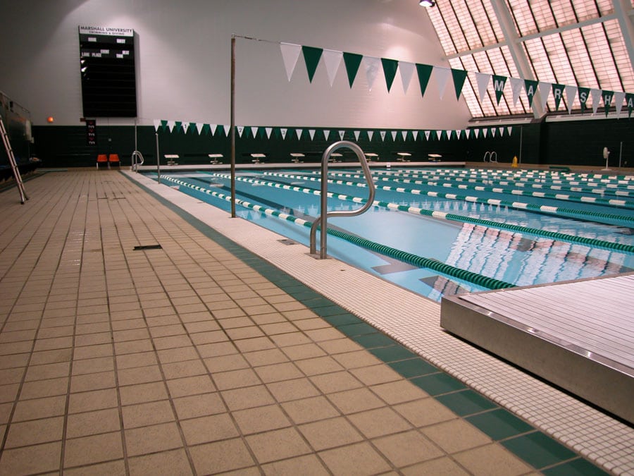 University swimming pool with gray quarry tile flooring, green borders, and white mosaic tile grid
