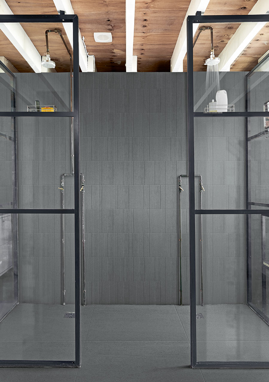 Basalt-look vertical striped tile in an industrial open shower