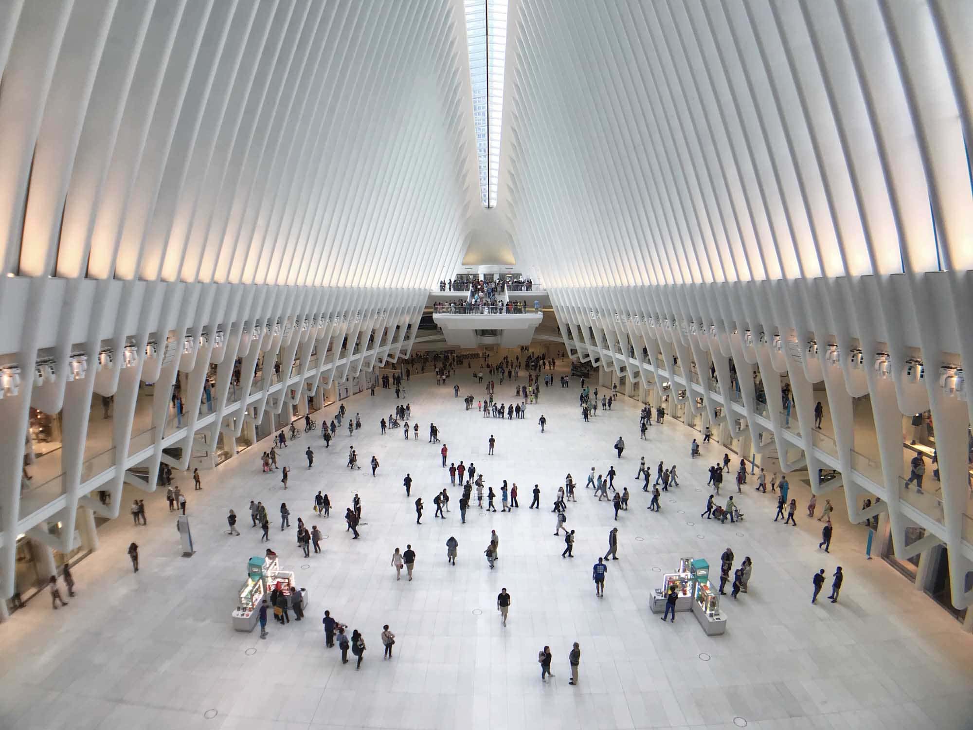 Spacious shopping mall interior with light ceramic tile flooring and modern architectural design