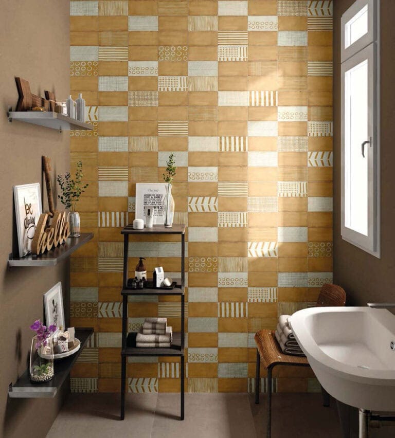 Random tile design on floor-to-ceiling bathroom accent wall with amber, dotted, striped and grid-patterned tiles