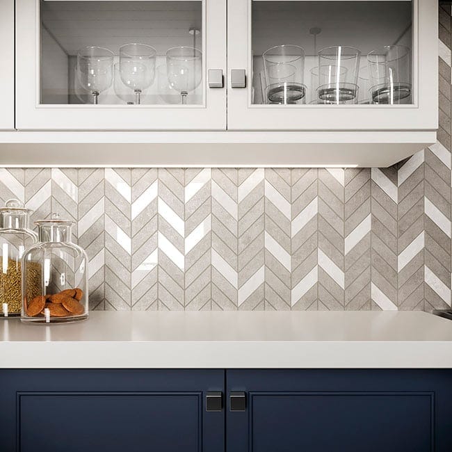 Random tile pattern in kitchen backsplash with chevron layout mixing white and taupe stone-look tiles