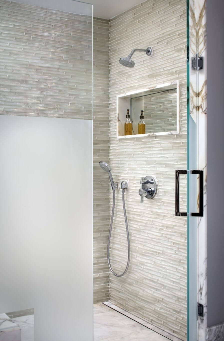 Shower wall tile ideas with dimensional linear mosaic tiles, frosted glass door and mirrored niche