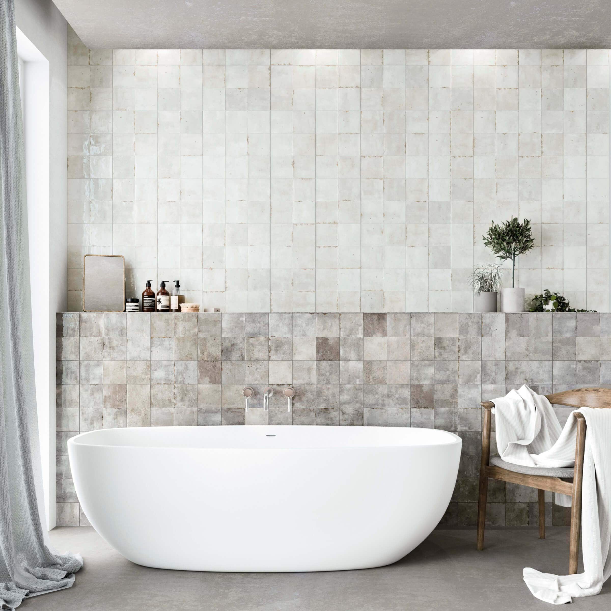 A modern bathroom with zellige wall tile, featuring a spacious tub and a stylish wooden chair