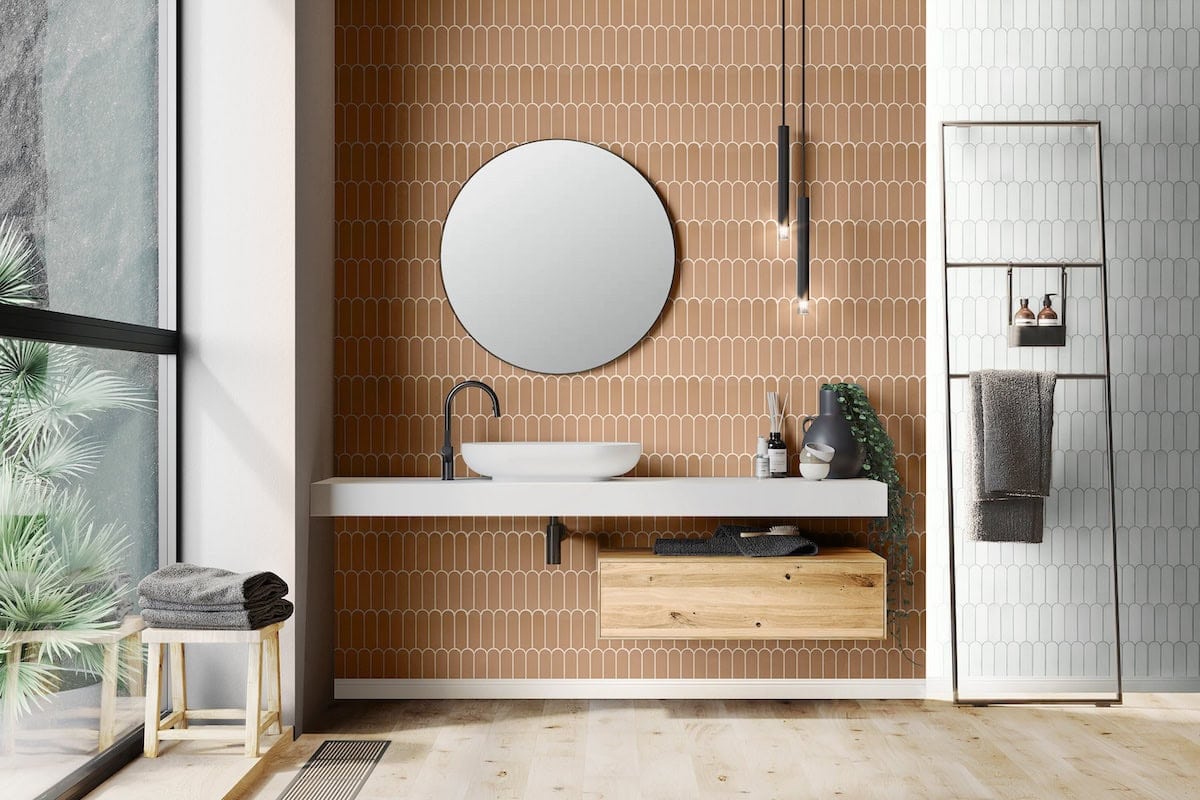 Bathroom with citrus-brown and white rounded picket tile walls and wood-look floor in a warm color-block design
