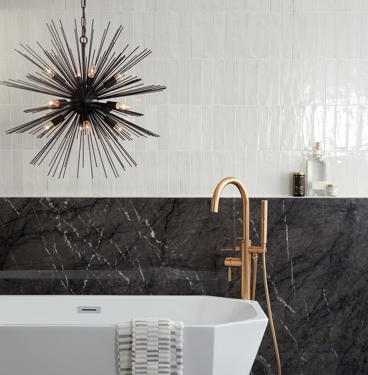 Bathroom with half white zellige tile and half black marble-look tile in a monochrome design