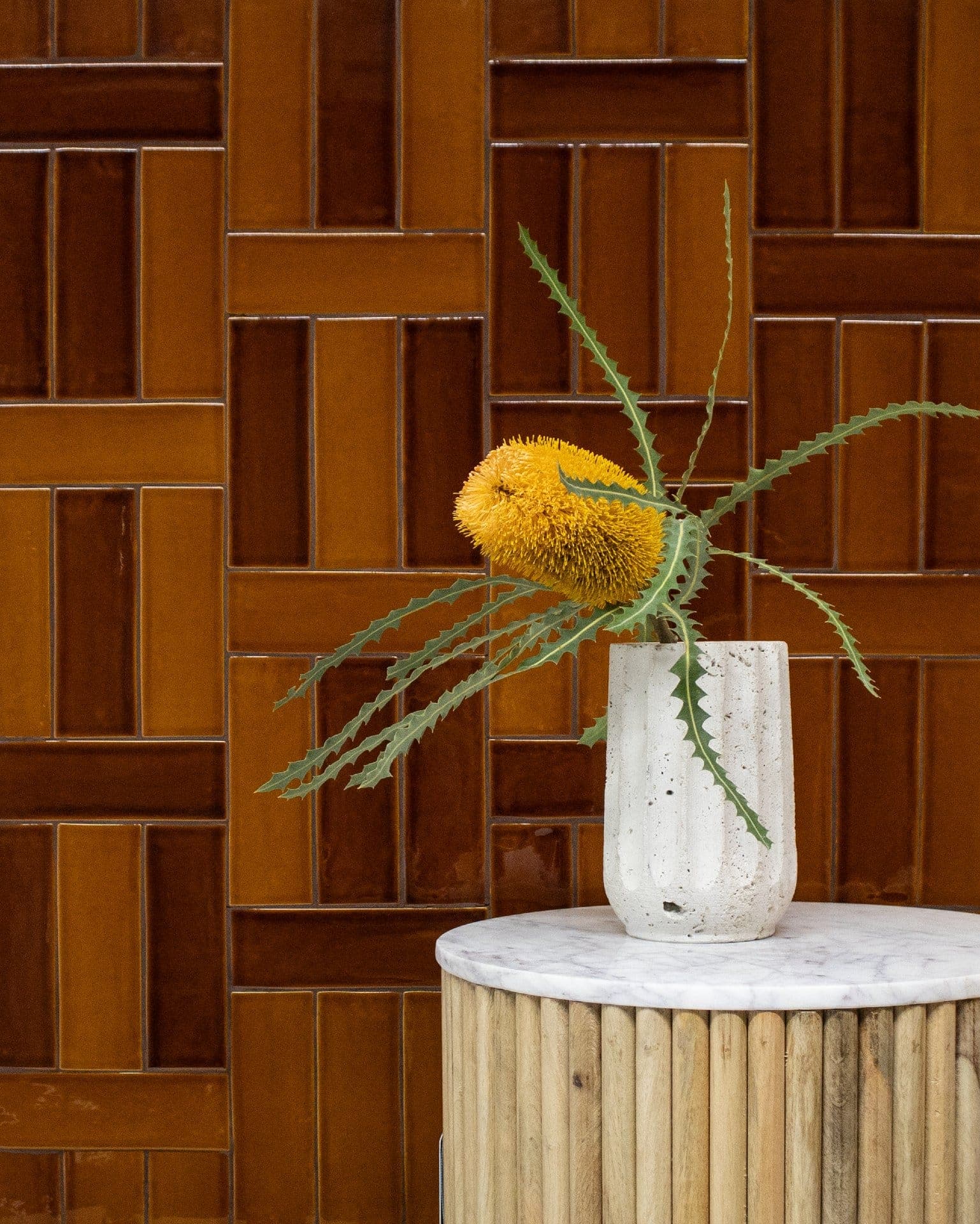 Space with terra-toned tiles are here to play in a modified crosshatch layout bouncing between amber and umber browns