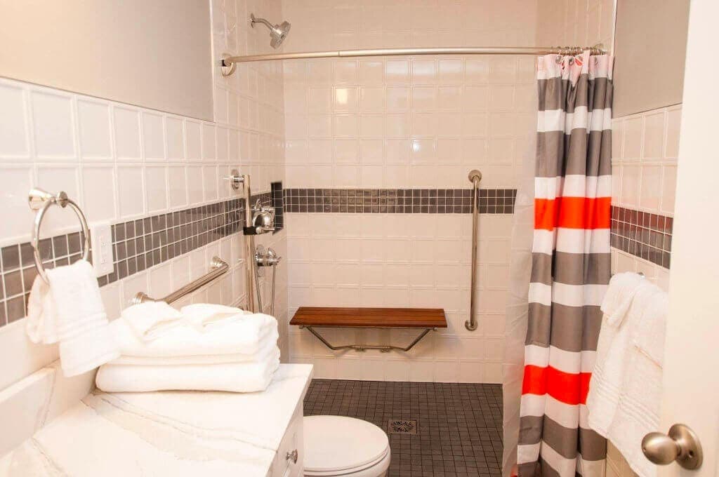 White bathroom with white backsplash tile and a gray tile border