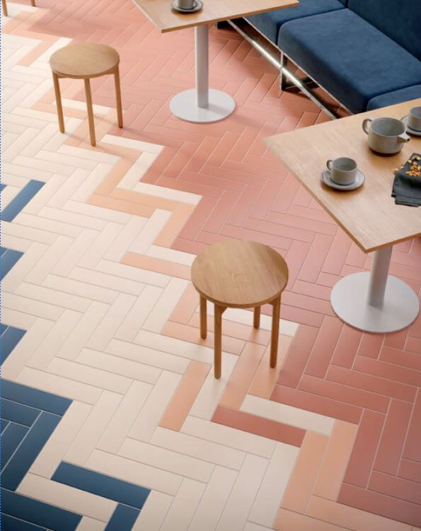 Kitchen floor with herringbone design and different pale blush pink floor tiles