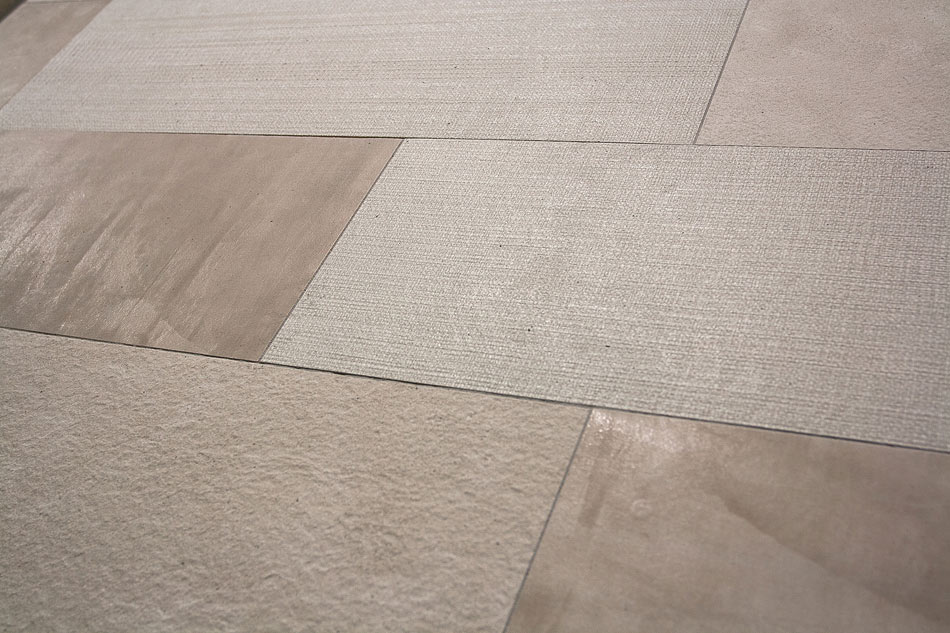 Close-up of floor tiles combining linen-look, plaster-look, and stone-look textures for a unique multi-textural design