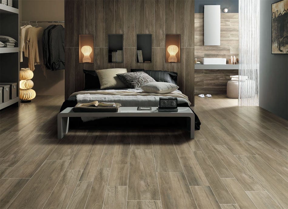 Cozy bedroom with wood-look ceramic tile sweeping across floors and walls
