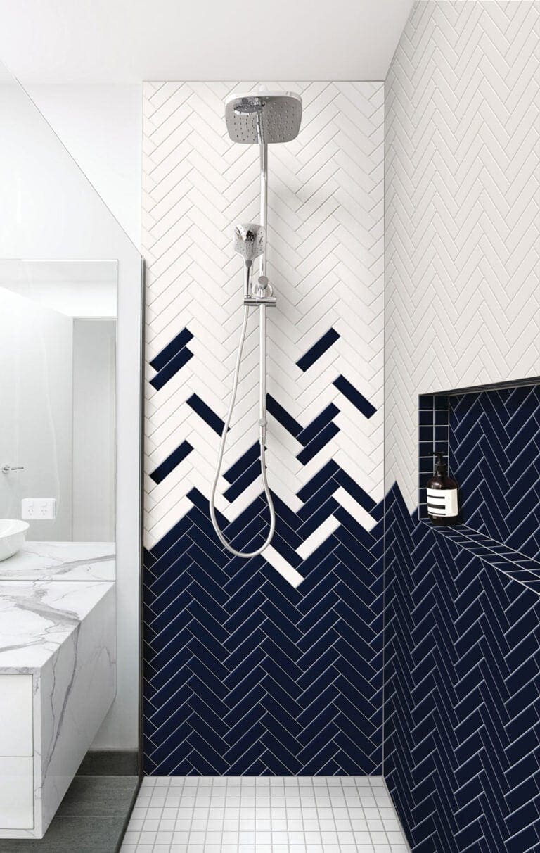 Random tile design in shower with herringbone layout transitioning from deep navy to white in a staggered color-block pattern