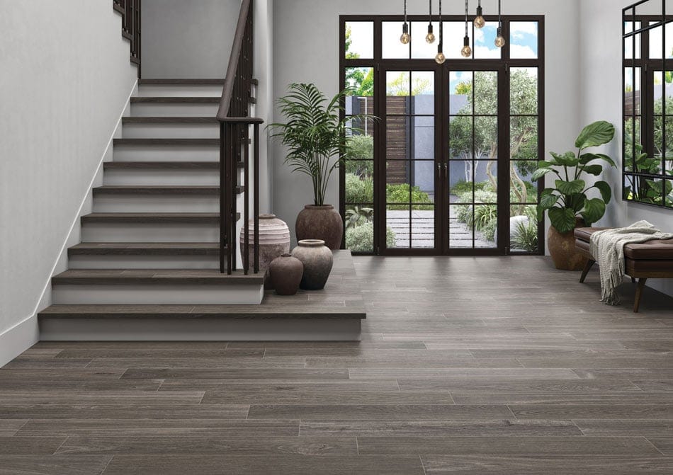 Entryway featuring dusky brown wood-look porcelain tile flooring and stairs in a traditional plank layout