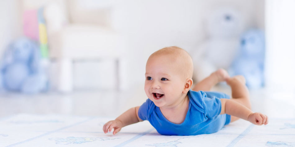 White and baby-blue blanket on neutral ceramic floor tile in a bright nursery with allergen-free, nontoxic materials