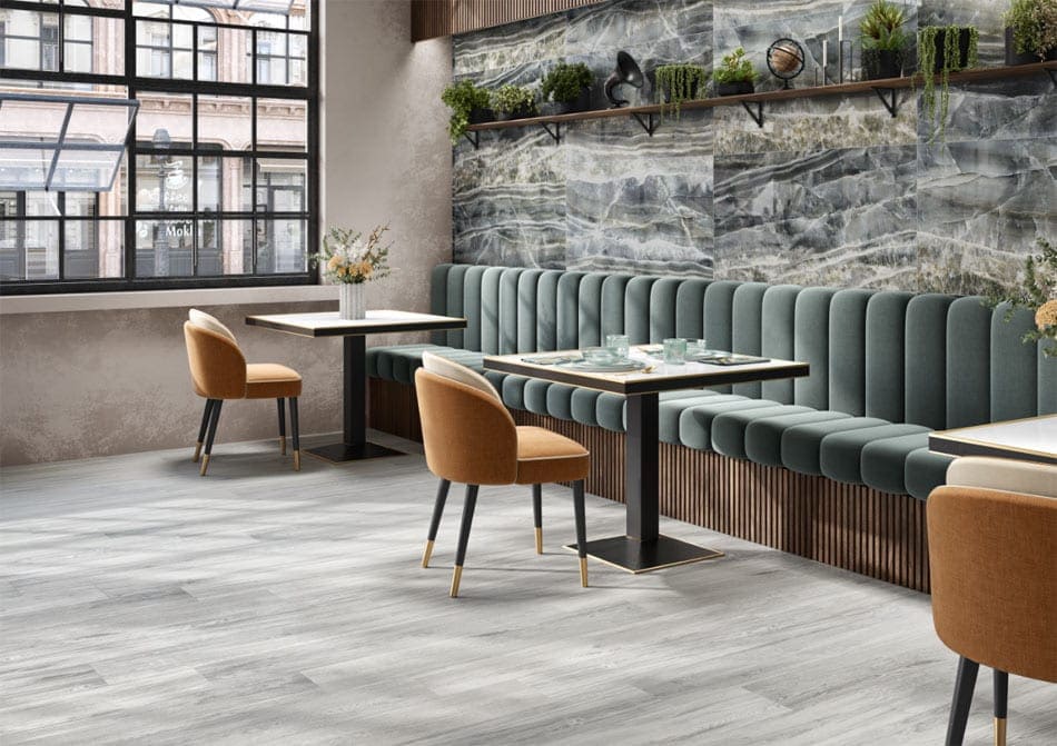 Modern restaurant interior featuring onyx-look porcelain tile wall with organic neutral tones, creating a biophilic effect