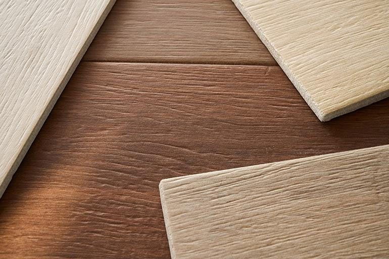 Detailed view of ceramic tile mimicking natural wood grain, highlighting the textural realism trend